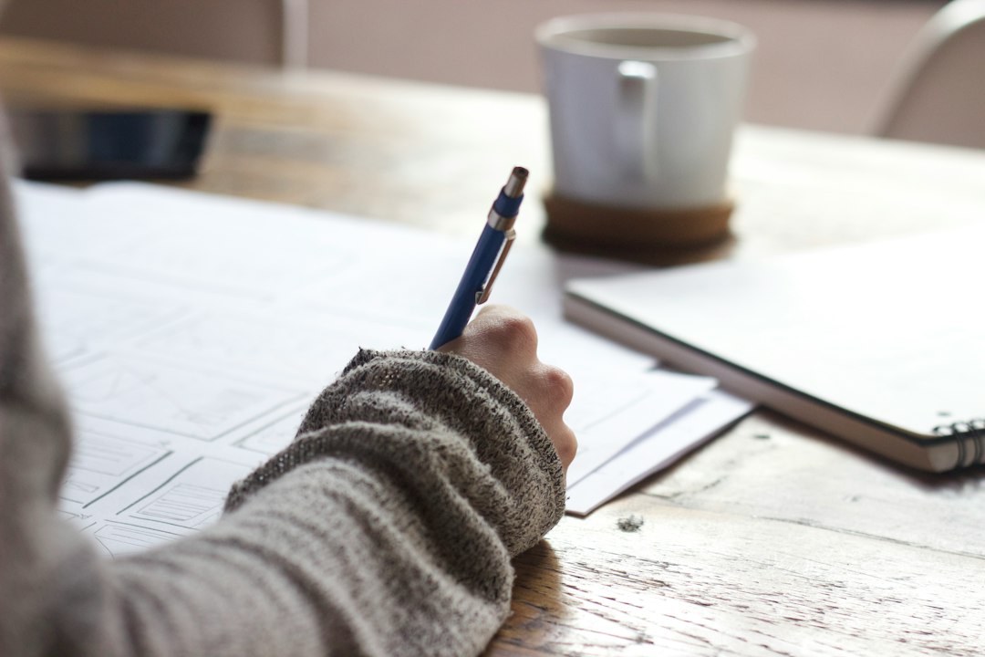 Person writing in a notebook at a desk, representing reflection, personal responsibility and purposeful action